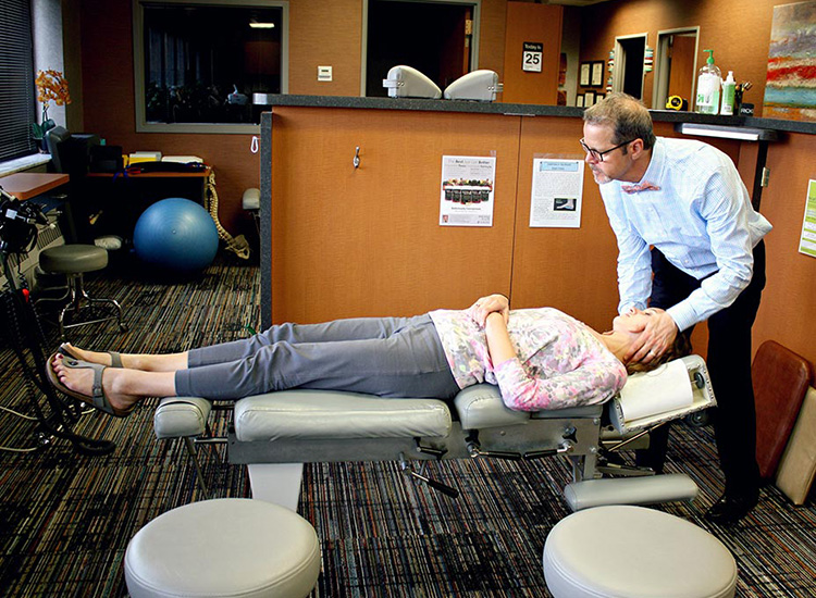 headache treatment service image button with Dr. Fargo administering an adjustment to a female patient